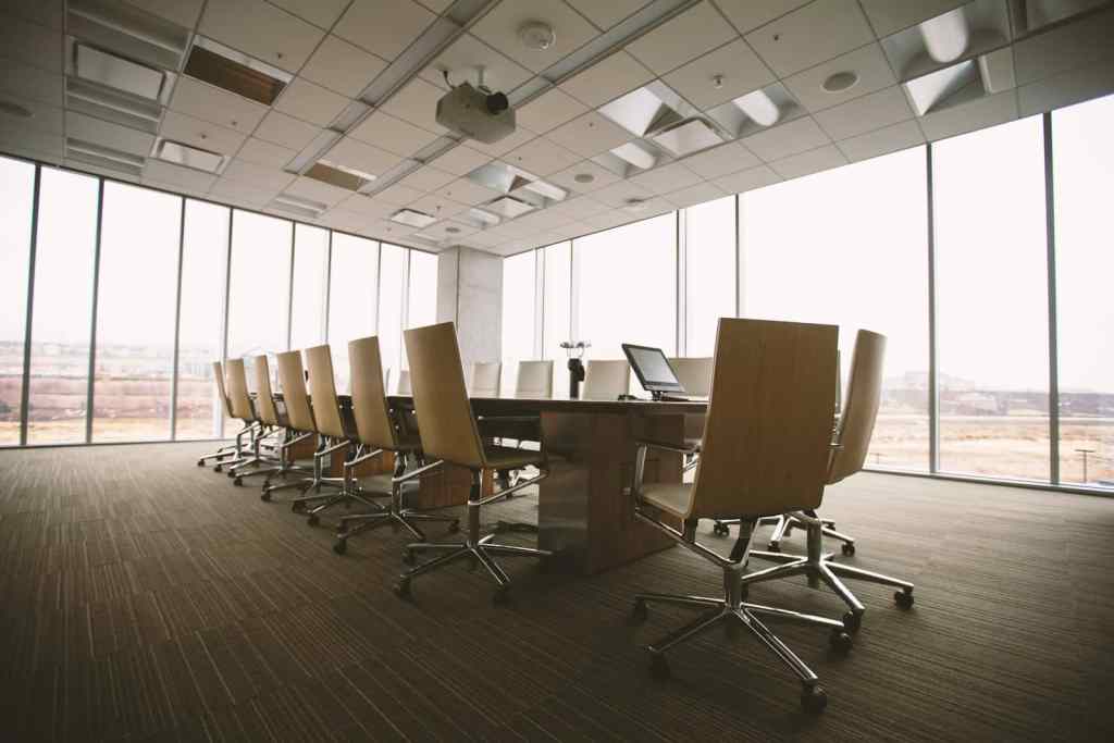 High-resolution image of a modern conference room with office chairs and large windows.