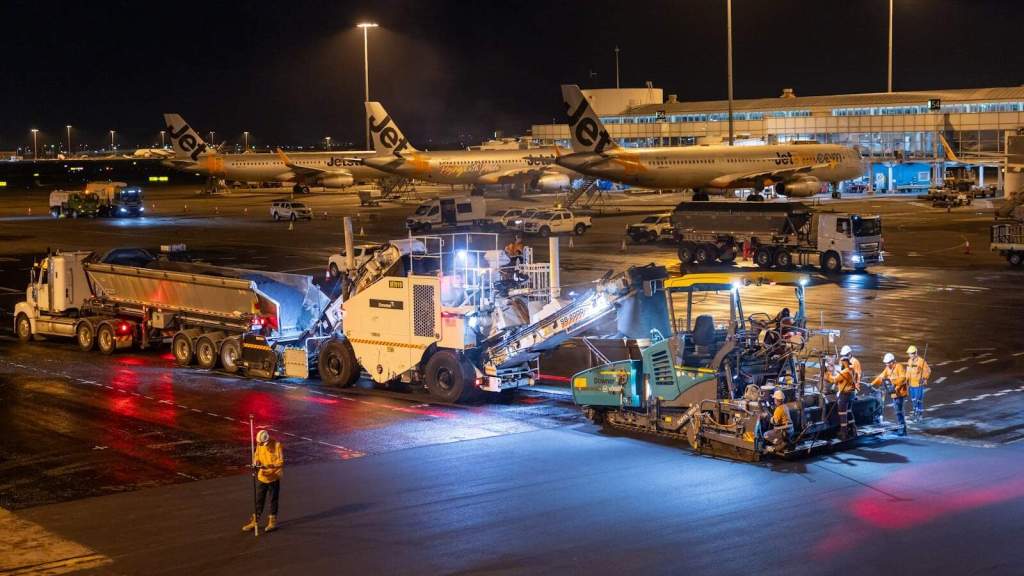 Airport construction debris removal equipment and personnel at work.