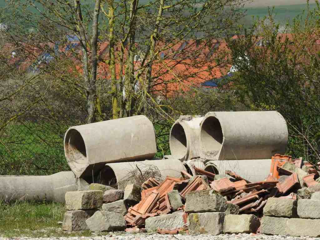 Concrete pipes and brick debris pile for removal.