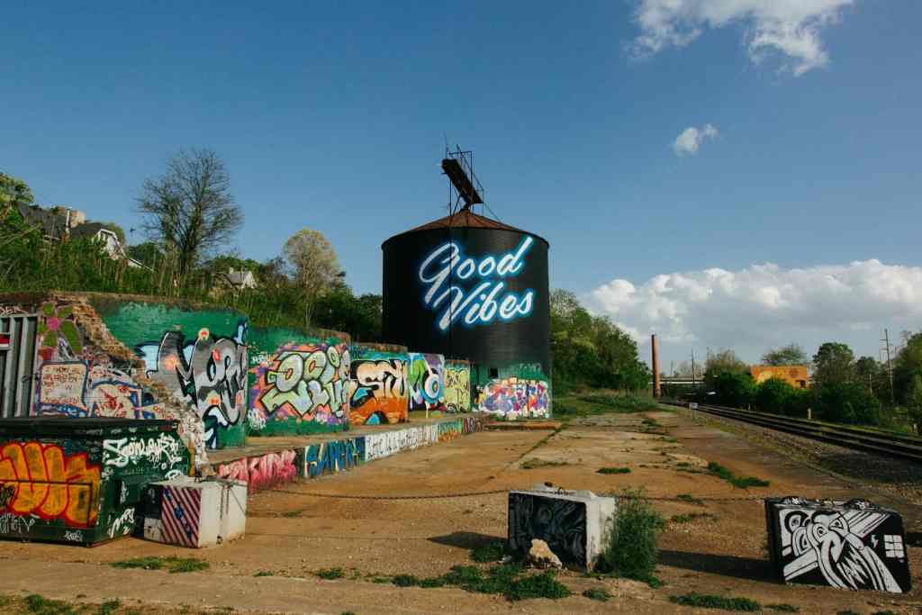 Bright graffiti artwork and "Good Vibes" sign at a colorful outdoor mural in Asheville, North Carolina.