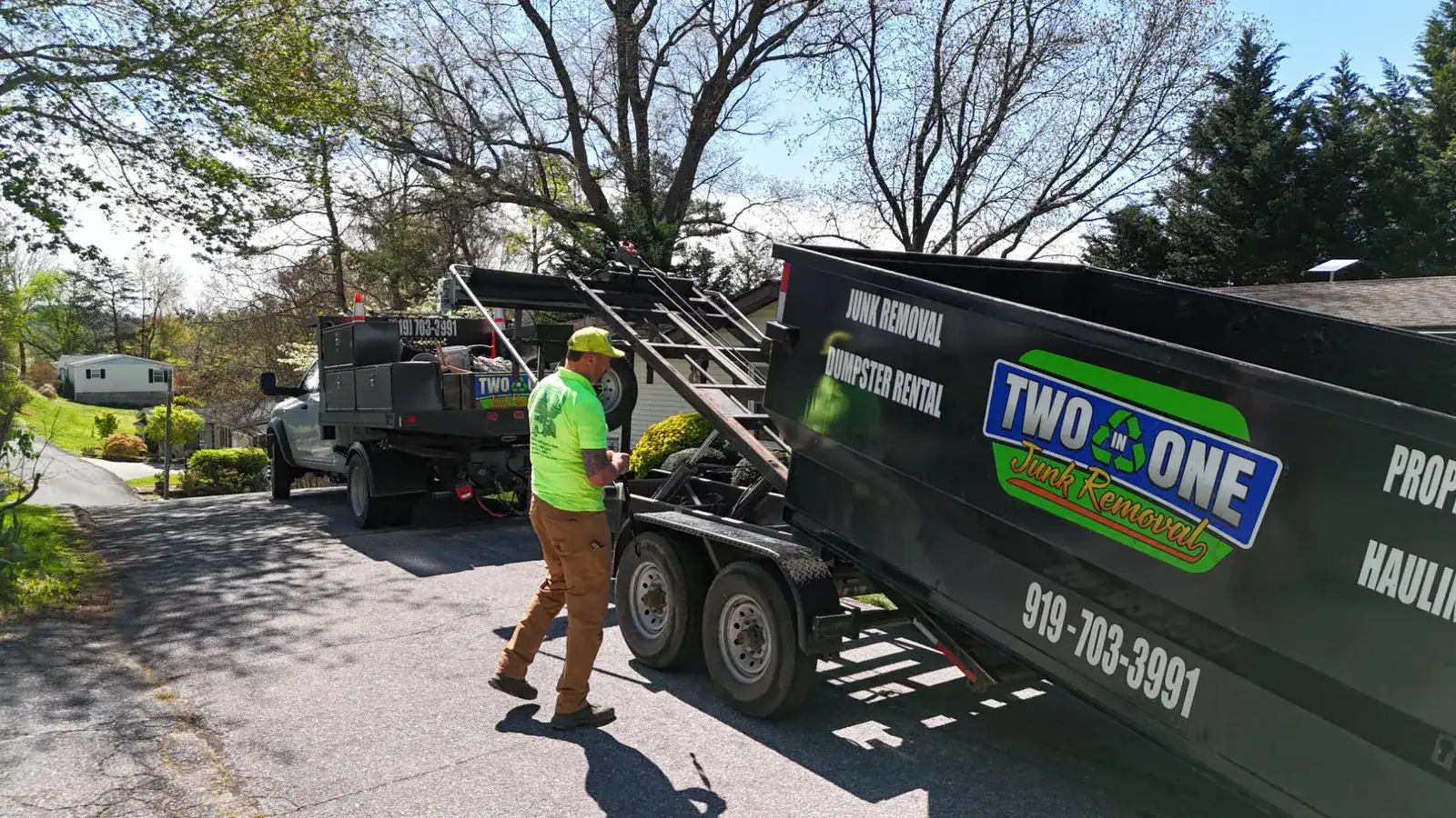 Two in One Junk Removal delivering a dumpster to a home driveway