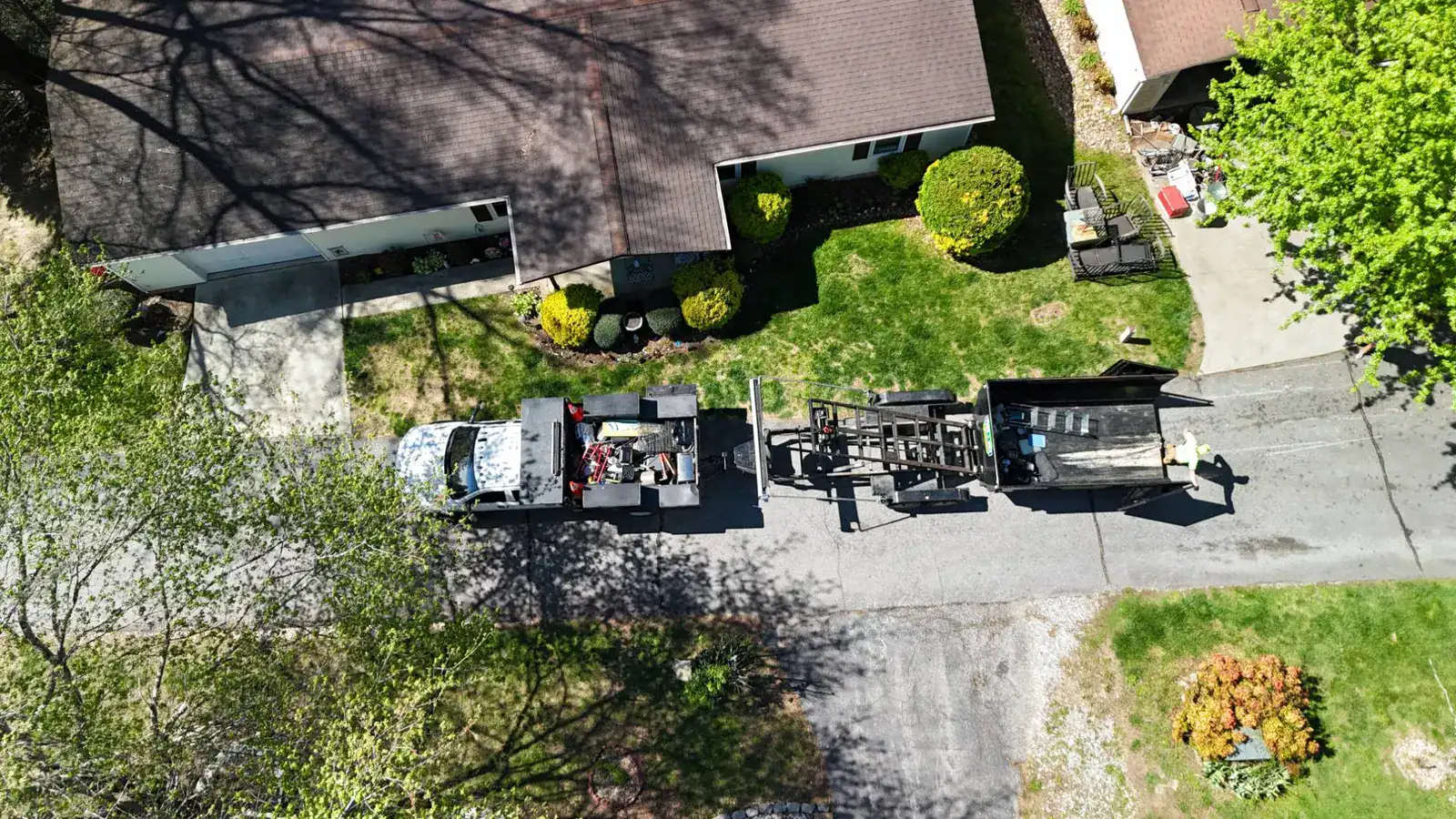 Two in One Junk Removal truck and dump trailer in a home driveway, seen from above